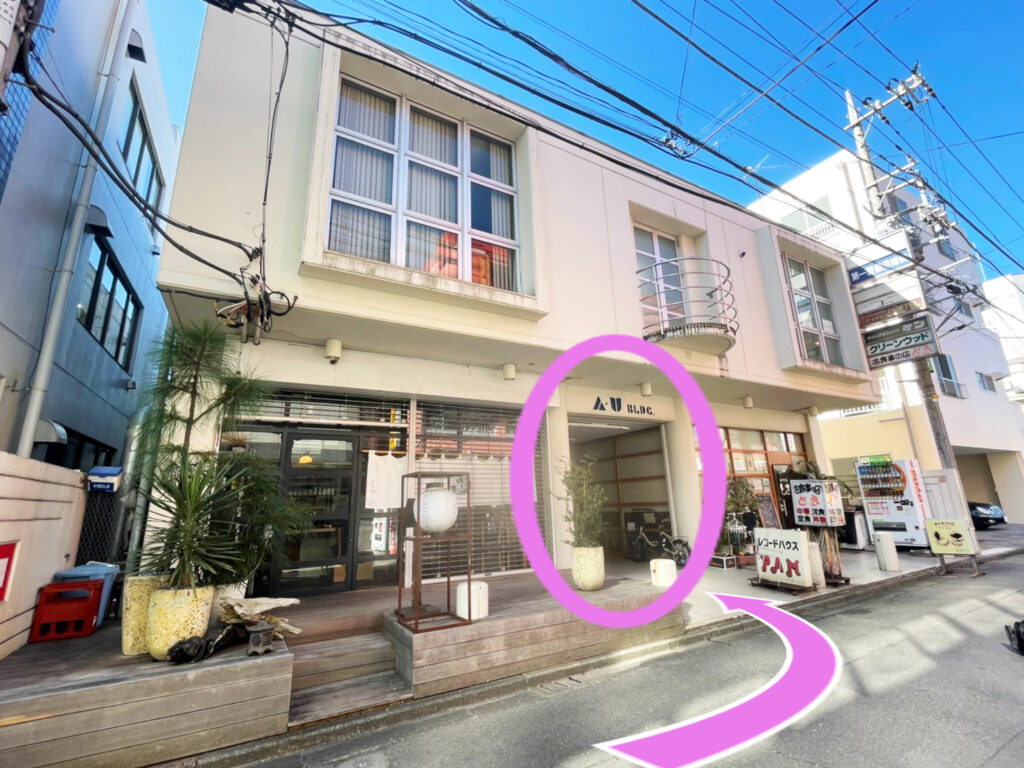 左手に白い2階建ての建物「AUビル」があります