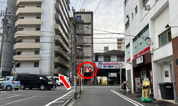 突き当たりまで進むと、指圧の看板のある建物が見えてきます。その左隣の建物が、当サロンのビル（アリウス）です。