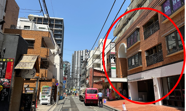 まっすぐ進むと右手に出てくる茶色い建物です。5階までのエレベータは建物の真ん中入り口ではなく、自動販売機がある建物左奥の入り口からとなります。
