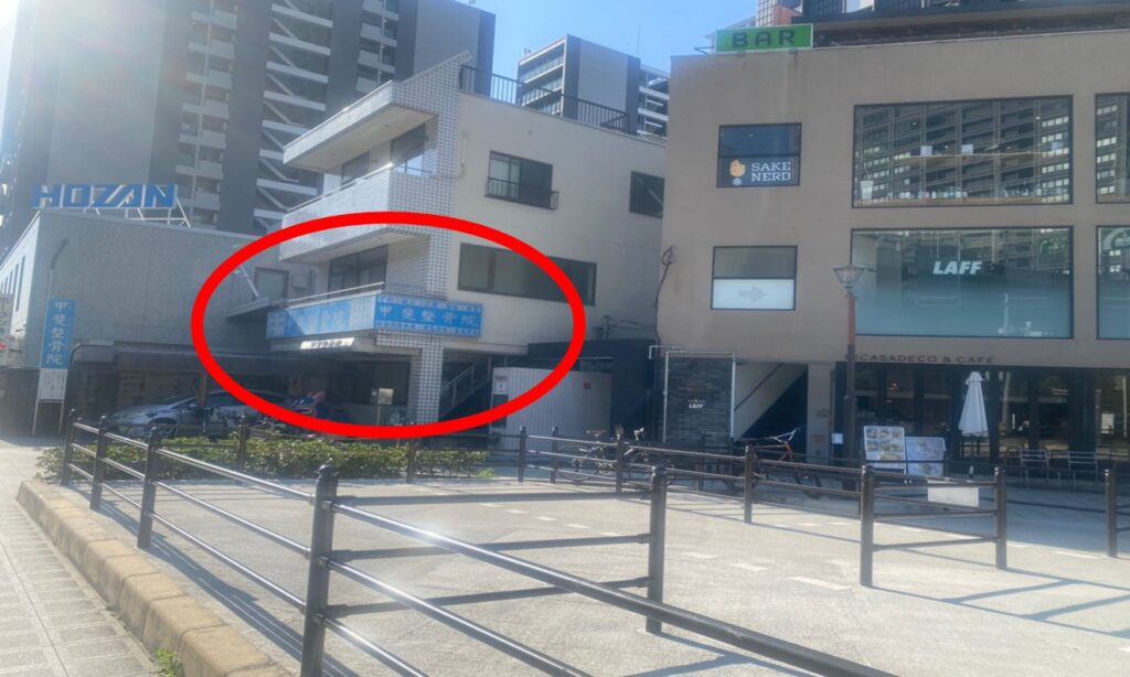 右手に青い整骨院のある建物が見えます