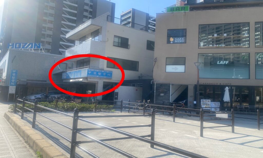 右手に青い整骨院のある建物が見えます